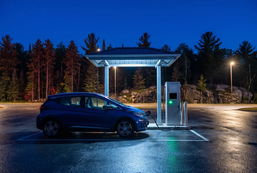 Electric hatchback at a charging post at night