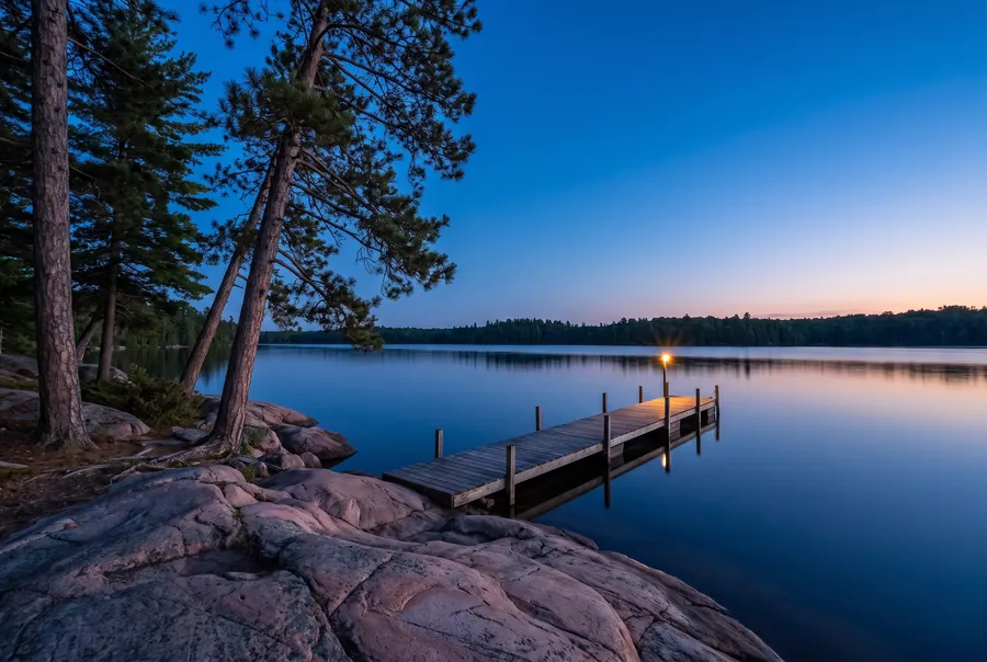 Granite shore of a northern lake at blue hour